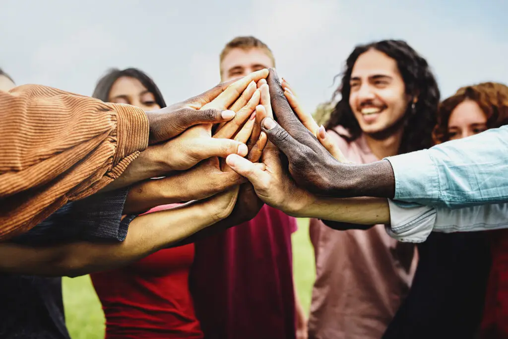 group of multi-ethnic community of happy people having fun joining hands