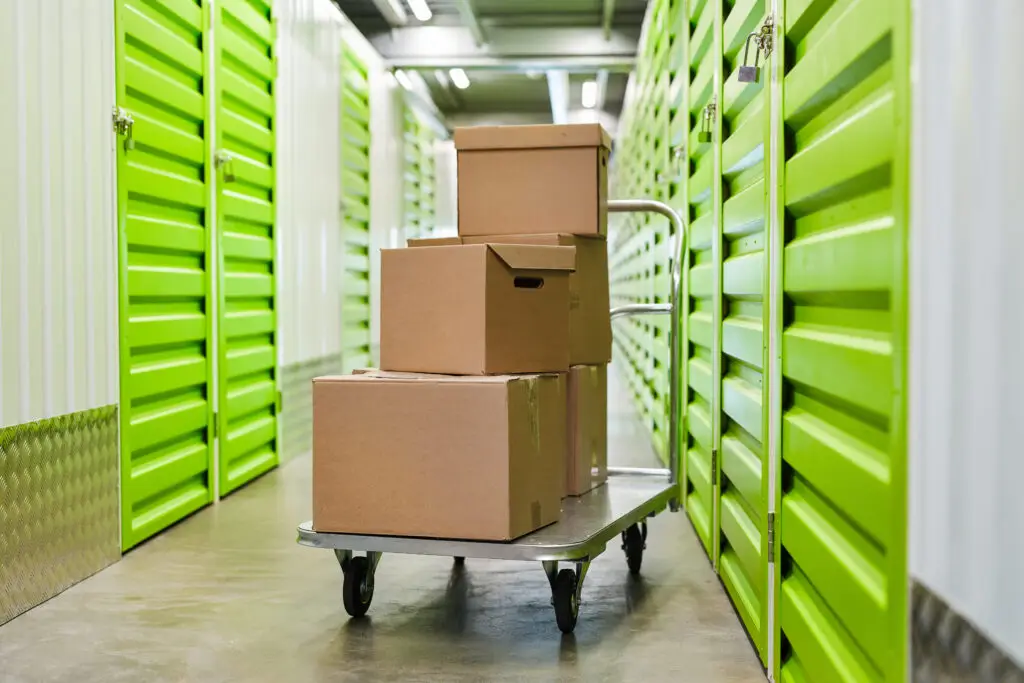 Cart with cardboard boxes in empty hall of self storage facility