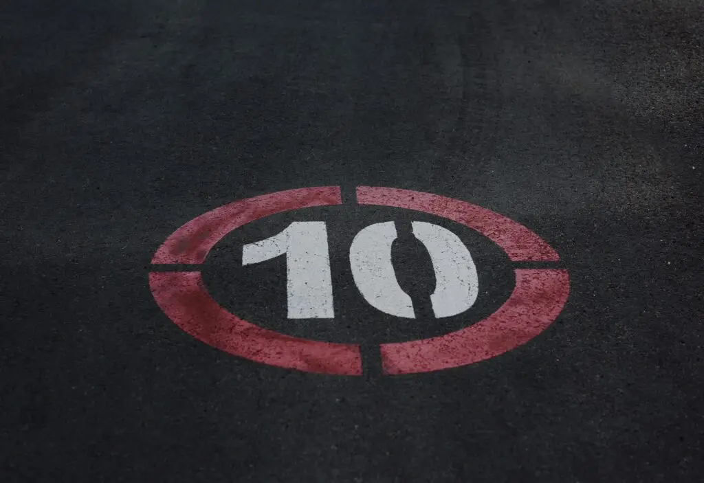 White number 10 circled in red painted on asphalt.