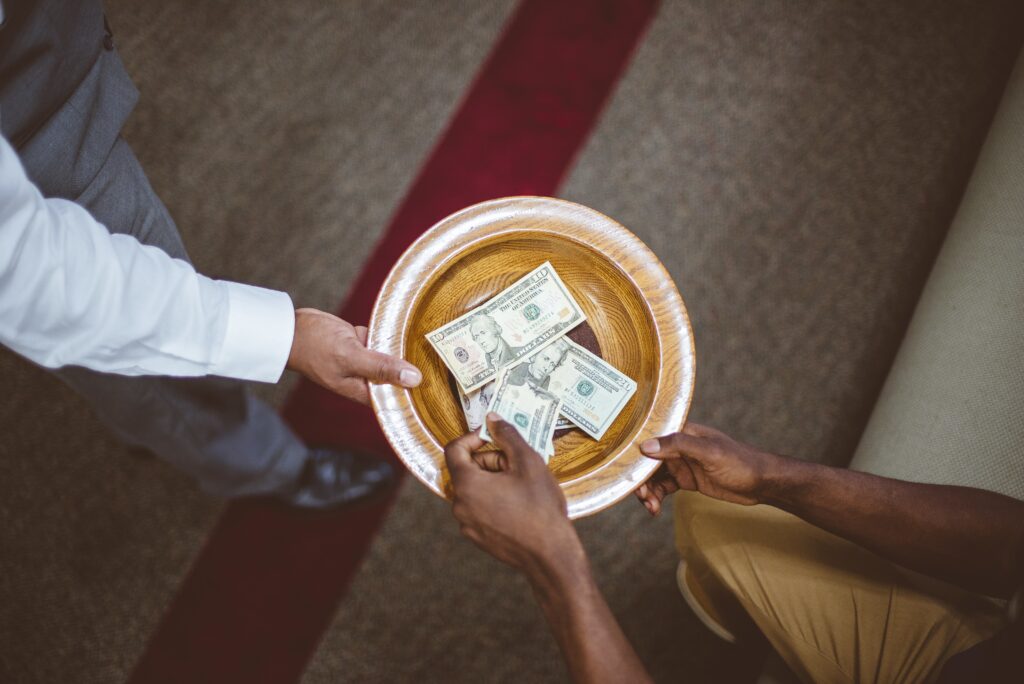 Overhead shot of a person collecting donations for the church with a blurred background