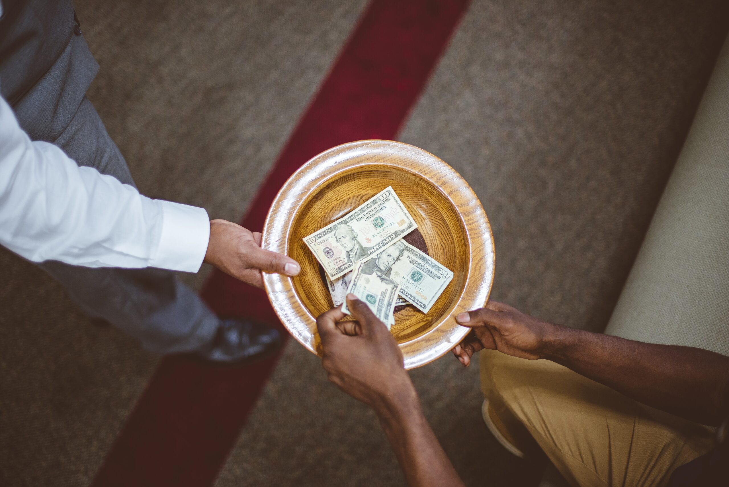 Overhead shot of a person collecting donations for the church with a blurred background