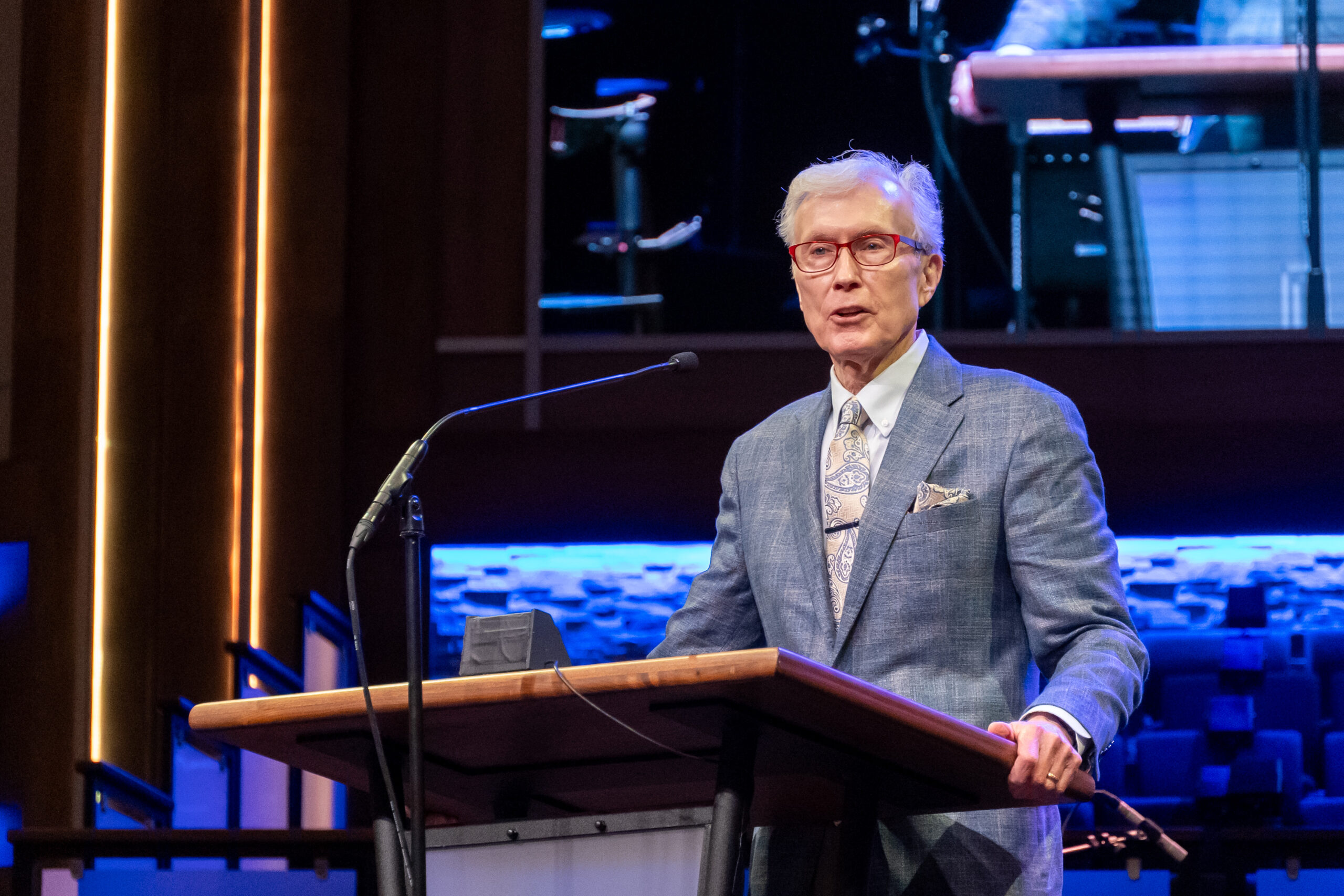 Home 1 Dr. Rick Lance speaks from behind a podium on stage at the Alabama Baptist State Convention Annual Meeting